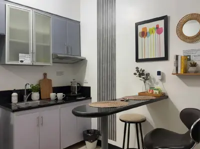 a kitchen with a counter and a table and chairs at Perfect Location BGC - Mckinley in Manila