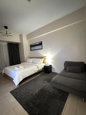 a bedroom with a white bed and a couch at 81 Newport Blvd Cluster 5 Unit 4E by Rechelle Nunag in Manila