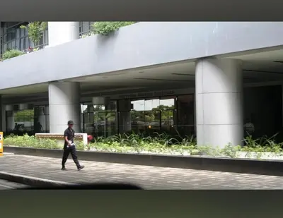 a man walking down a sidewalk in front of a building at 81 Newport Blvd Cluster 5 Unit 4E by Rechelle Nunag in Manila