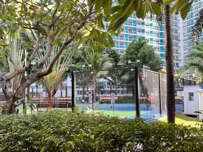 a group of people playing tennis on a tennis court at Azure Staycation Condo Unit in Manila