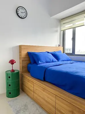 a bedroom with a bed and a clock on the wall at Cozy Mid-Century Condo with a Skyline View in Manila