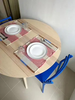 a wooden table with two white plates on it at Cozy Mid-Century Condo with a Skyline View in Manila