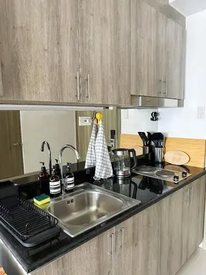 a kitchen with a sink and a counter top at Cozy Mid-Century Condo with a Skyline View in Manila