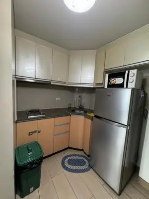 a kitchen with a stainless steel refrigerator and a trash can at Alaya Place - Palm Tree II - in front of NAIA 3 in Manila