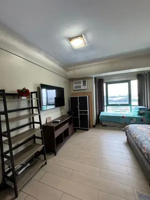 a room with a bedroom with a bed and a television at Alaya Place - Palm Tree II - in front of NAIA 3 in Manila