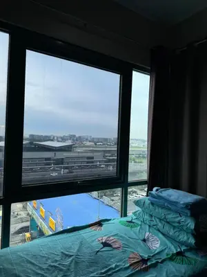 a bedroom with a view of an airport from a window at Alaya Place - Palm Tree II - in front of NAIA 3 in Manila