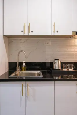 a kitchen with white cabinets and a sink at Luxe 1BR with WiFi, Karaoke and Balcony Near SM Megamall in Manila