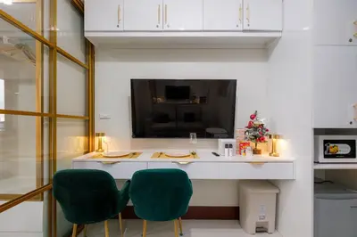 a kitchen with a counter with two green chairs at Luxe 1BR with WiFi, Karaoke and Balcony Near SM Megamall in Manila