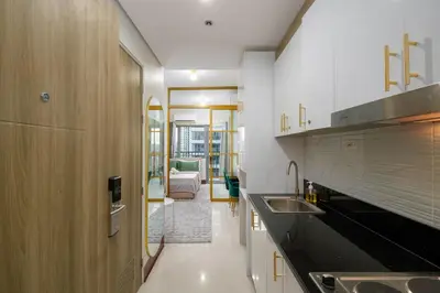 a kitchen with a sink and a living room at Luxe 1BR with WiFi, Karaoke and Balcony Near SM Megamall in Manila