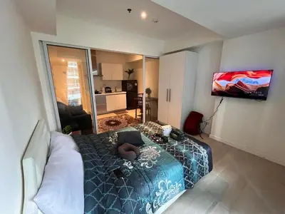 a room with a bed and a television in it at Staycation in Azure Paranaque in Manila