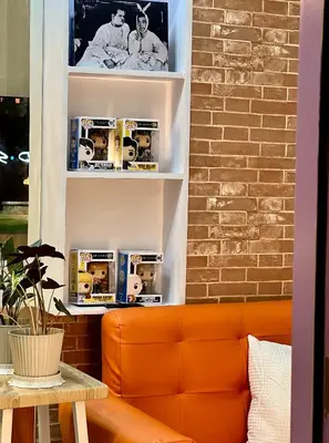 an orange couch in a room with a brick wall at FRIENDS TV Staycation in Manila