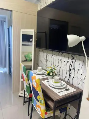 a dining room table with chairs and a lamp at JAZZ RESIDENCES- Amaya Stays in Manila