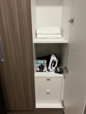 a room with a closet with white shelves and a door at Holiday suite at Park Mckinley West in Manila