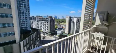 a view of a city from the balcony of a building at Holiday suite at Park Mckinley West in Manila