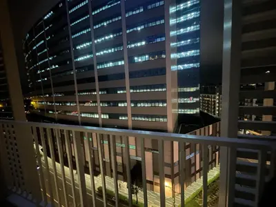 a view from the balcony of a building at night at Holiday suite at Park Mckinley West in Manila