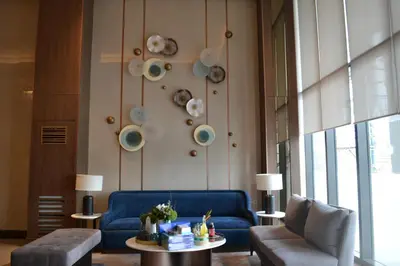a living room with a blue couch and a table at Gentry Manor Near MOA&Airport WiFi TV Netflix Okada view 6Q in Manila