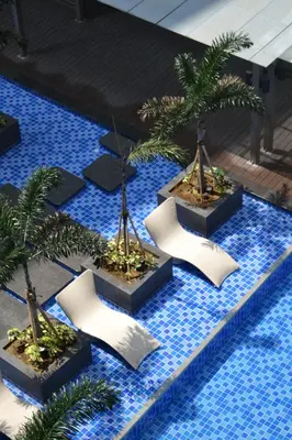 a group of palm trees in a swimming pool at Gentry Manor Near MOA&Airport WiFi TV Netflix Okada view 6Q in Manila