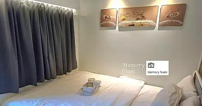 a bedroom with a bed with two paintings on the wall at Velvet Room near MOA with a Cozy, Comfy Bed in Manila