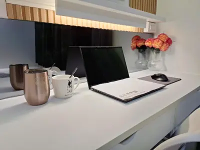 a laptop computer sitting on top of a white desk at Velvet Room near MOA with a Cozy, Comfy Bed in Manila