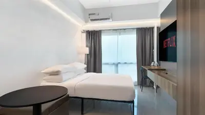 a hotel room with a white bed and a table at Sky Suite Makati Modern Penthouse near Greenbelt in Manila
