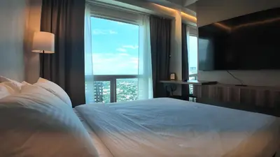 a bedroom with a large bed with a large window at Sky Suite Makati Modern Penthouse near Greenbelt in Manila