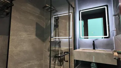 a bathroom with a shower and a sink and a mirror at Sky Suite Makati Modern Penthouse near Greenbelt in Manila