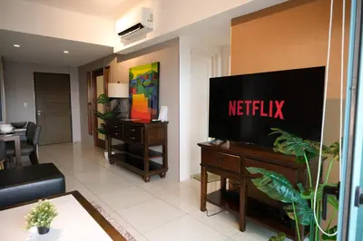 a living room with a flat screen tv on a wall at One Uptown Premium 2BR Suite in Manila