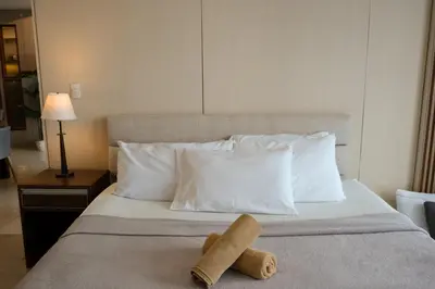 a hotel room with a bed with two towels on it at One Uptown Premium 2BR Suite in Manila