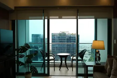 a living room with a view of a city at One Uptown Premium 2BR Suite in Manila