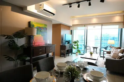 a living room with a dining table and a living room at One Uptown Premium 2BR Suite in Manila