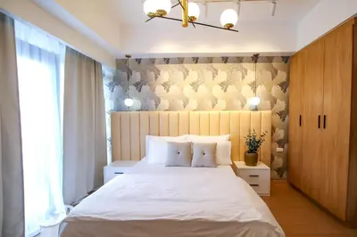 a bedroom with a large white bed and a window at Cylo's Place Manhattan in Manila