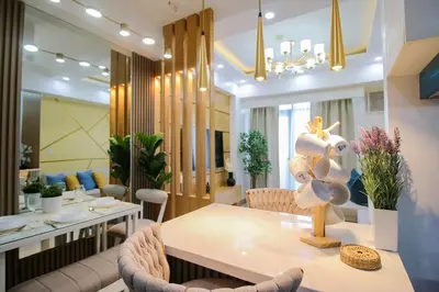 a dining room and living room with a table and chairs at Cylo's Place Manhattan in Manila