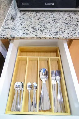 a drawer with silver utensils on a kitchen counter at Cylo's Place Manhattan in Manila