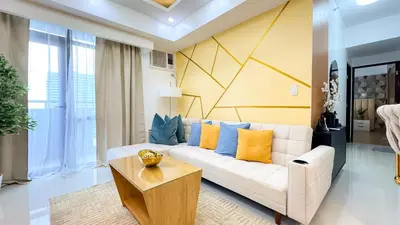 a living room with a white couch and a table at Cylo's Place Manhattan in Manila