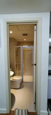 a bathroom with a toilet and a walk in shower at Azure Family Room Condo Unit in Manila