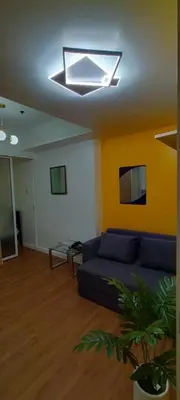 a living room with a blue couch and a window at Azure Family Room Condo Unit in Manila