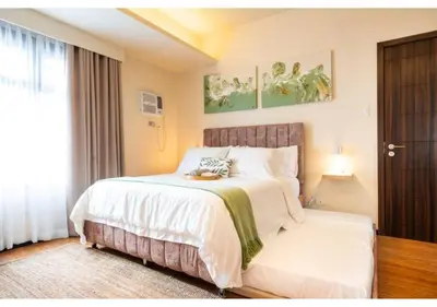 a bedroom with a large white bed and a window at The Bay Nest in Manila