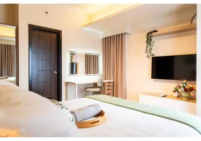 a hotel room with a bed and a television at The Bay Nest in Manila