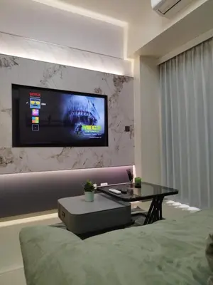 a room with a bed and a tv on a wall at Savvy Suite 1BR near Okada in Manila