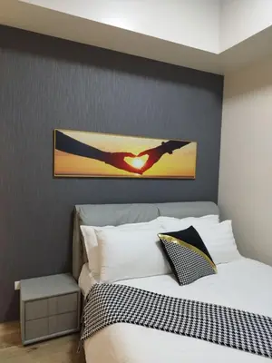 a bedroom with a bed with a heart picture on the wall at Savvy Suite 1BR near Okada in Manila