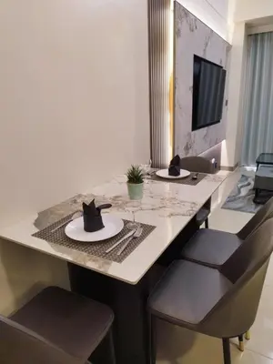 a dining table with two chairs and a hat on it at Savvy Suite 1BR near Okada in Manila