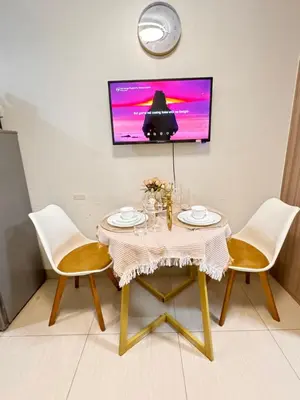 a dining room table with two chairs and a tv at La Chicka Staycation -1292 in Manila