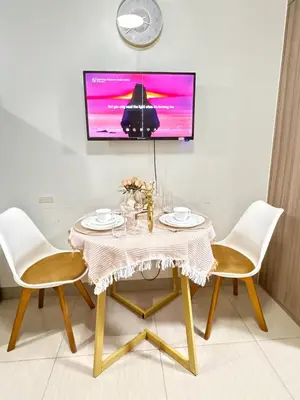 a dining room table with two chairs and a tv at La Chicka Staycation -1292 in Manila