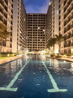 a large swimming pool in front of a building at La Chicka staycation in Manila