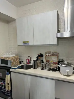 a kitchen with a sink and a counter top at Uno Tahanan Azure in Manila
