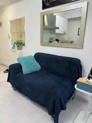 a blue couch in a room with a mirror at Uno Tahanan Azure in Manila