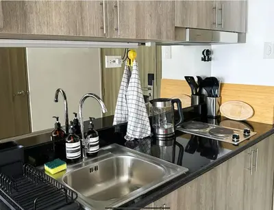 a kitchen with a sink and a counter top at Cozy Mid-Century Condo with a Skyline View in Manila