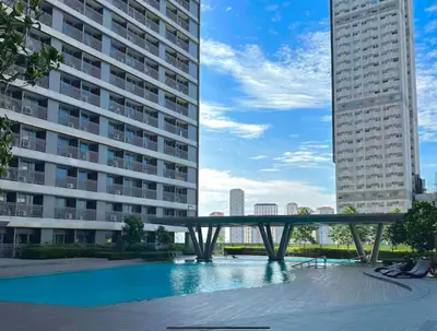 a pool in the middle of two tall buildings at Cozy Mid-Century Condo with a Skyline View in Manila