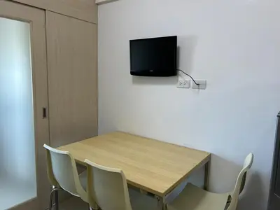a table with chairs and a television on a wall at 1-Br Unit at Light Residences in Manila