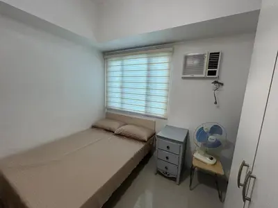 a small bedroom with a bed and a window at 1-Br Unit at Light Residences in Manila